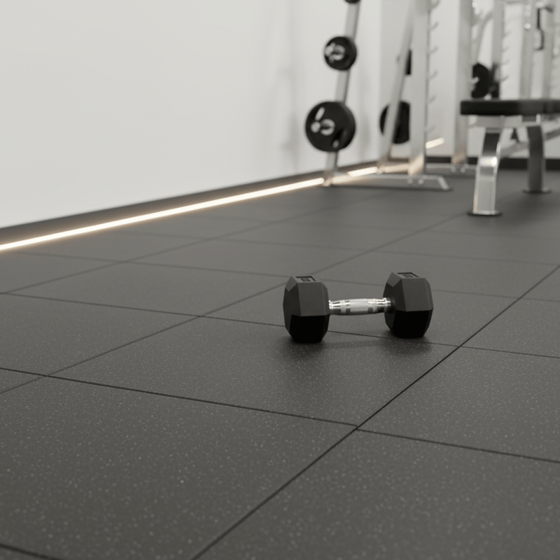 Dumbbells on a black tiled floor in a gym setting